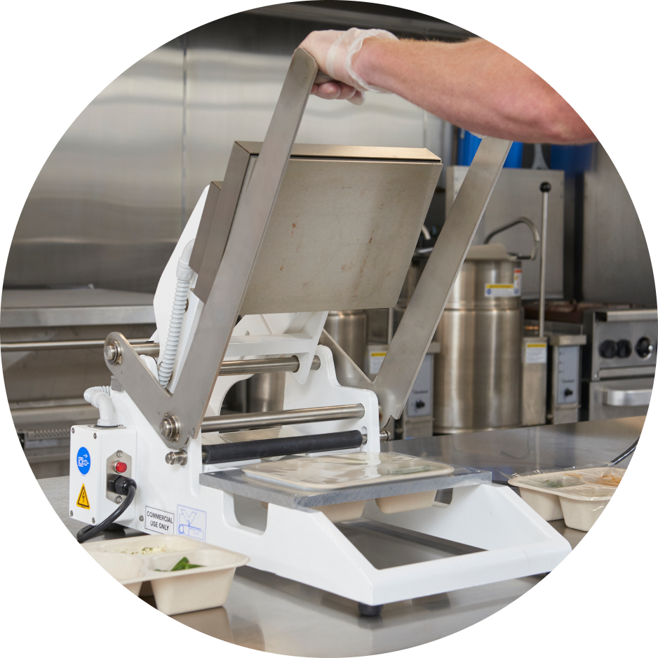 Food tray sealing machine in use